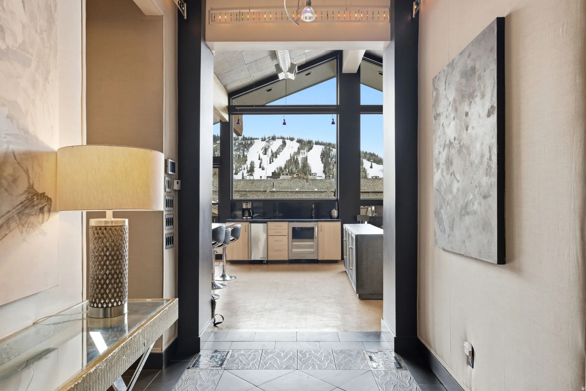 Expansive floor-to-ceiling windows frame a mountain backdrop