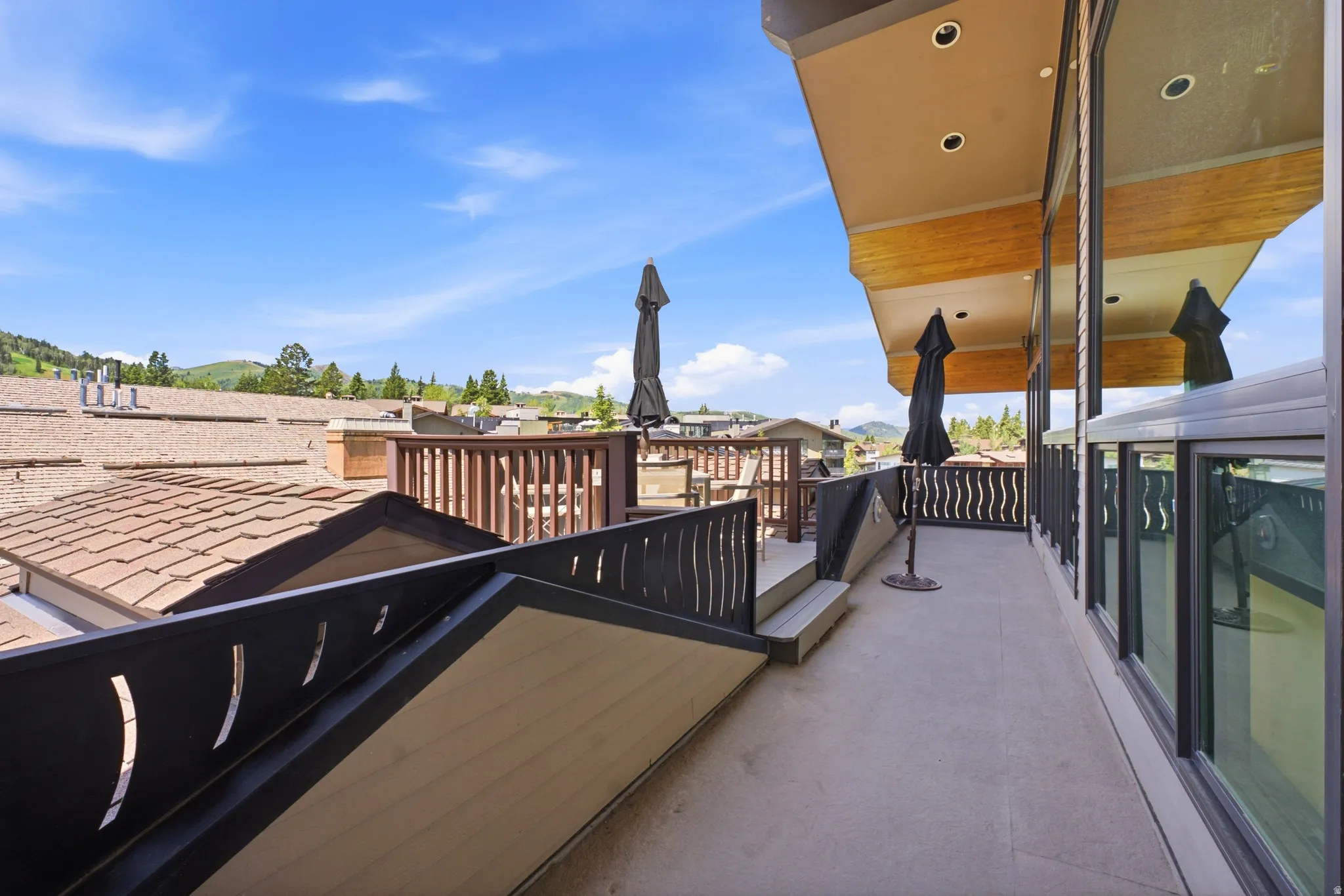 Spacious outdoor terrace with concrete flooring and dark-framed windows