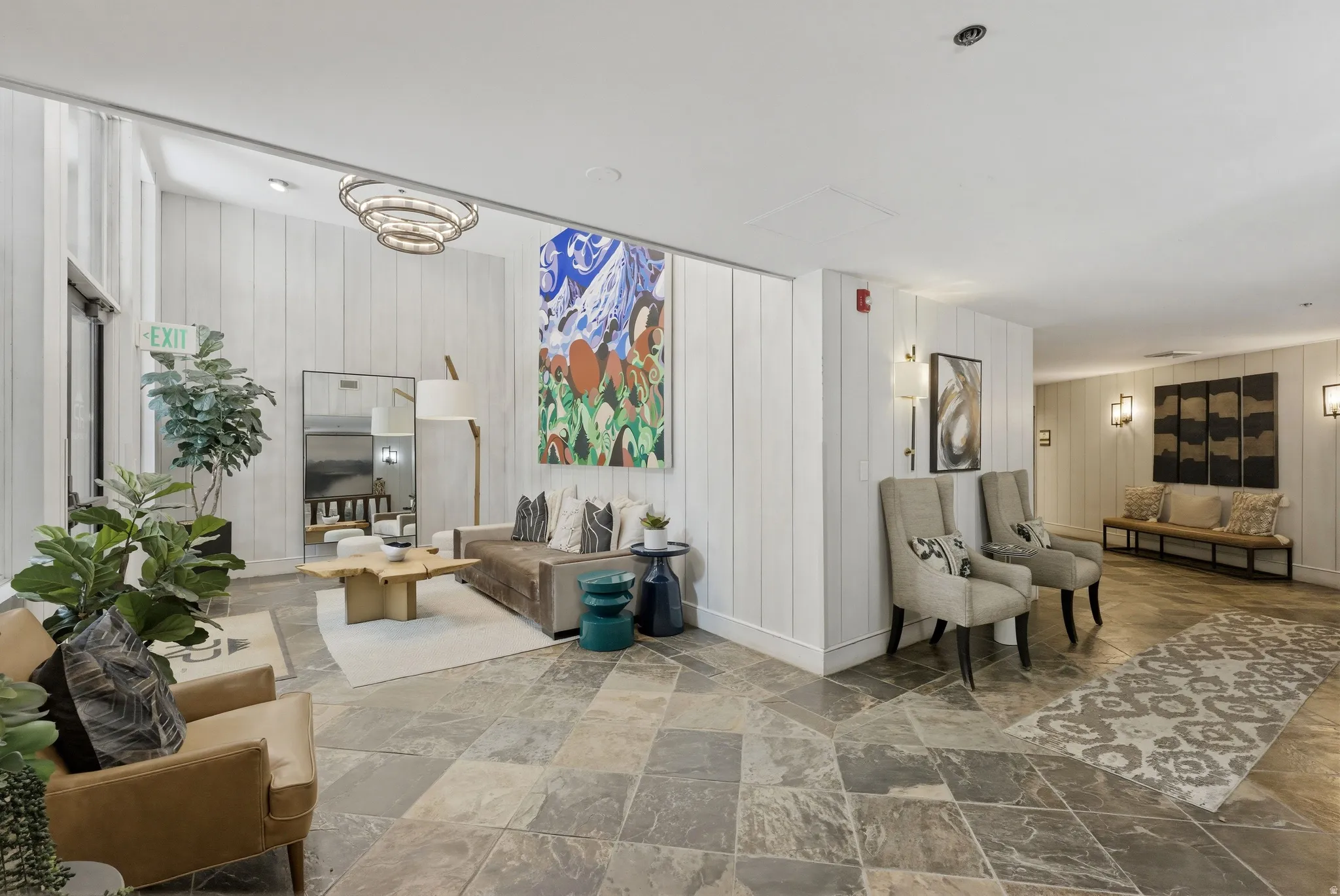 Expansive lobby featuring natural stone tile flooring and white vertical paneling