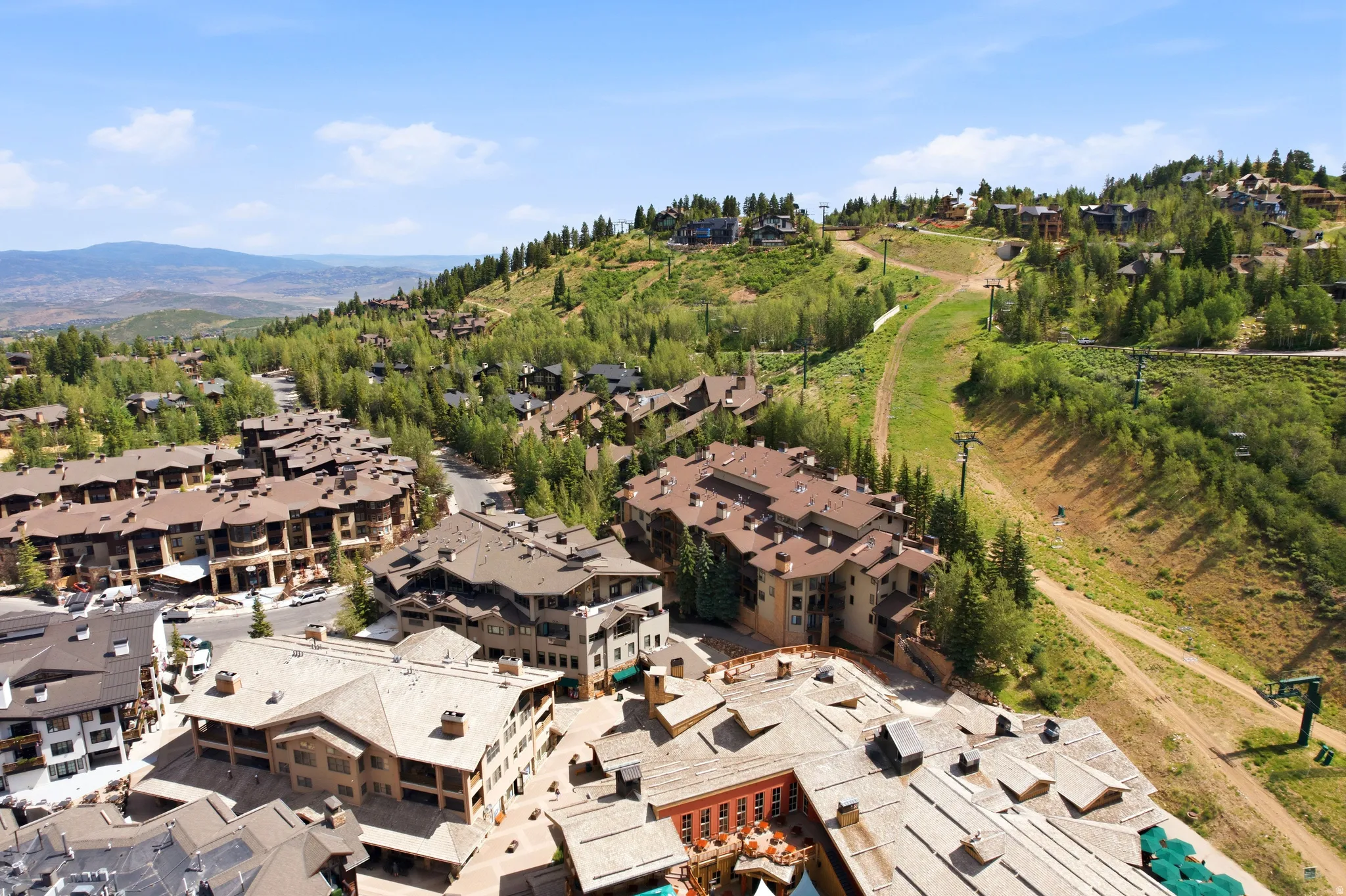 Mountain resort community featuring multi-story residences, varied rooflines, and extensive surrounding greenery
