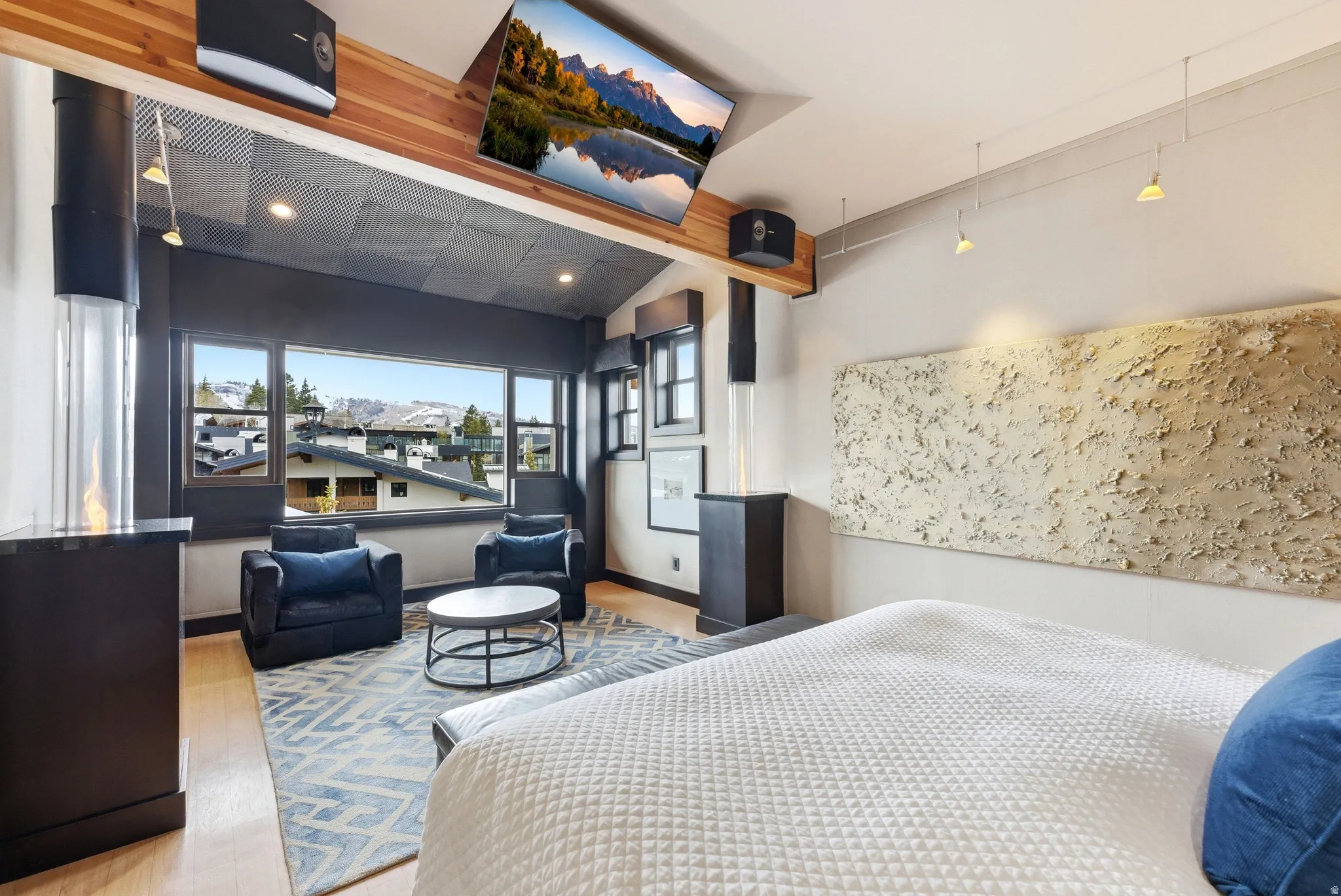 Hardwood flooring complements a contemporary fireplace with a glass enclosure
