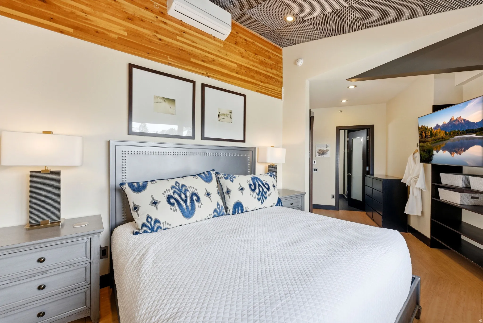 Bedroom featuring a wood plank accent wall, recessed lighting, and wood-finish flooring