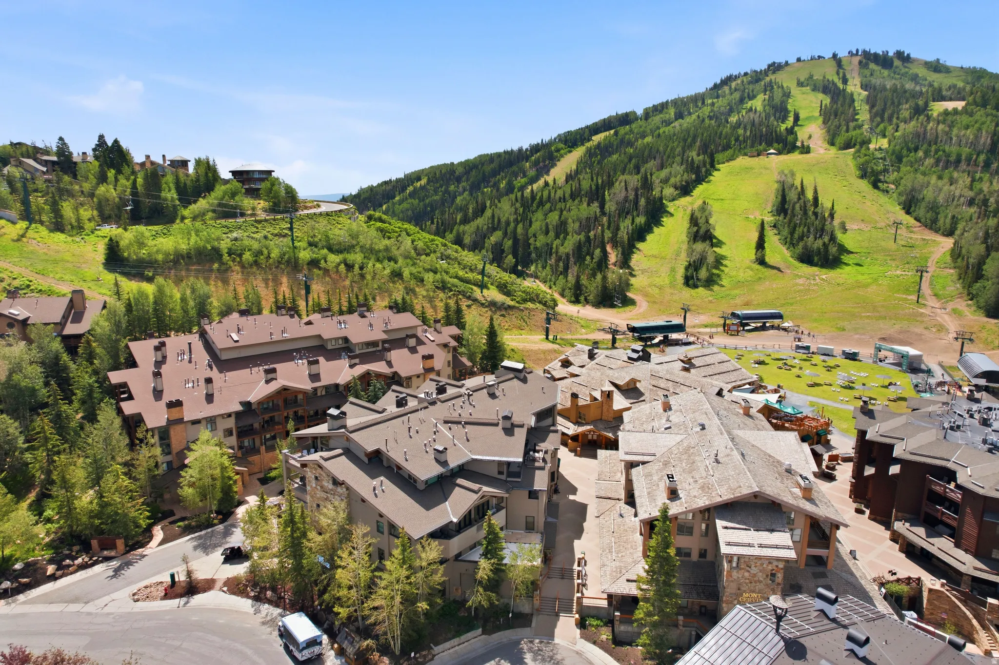 Mountain resort community featuring multi-story buildings with brown roofs and extensive surrounding greenery