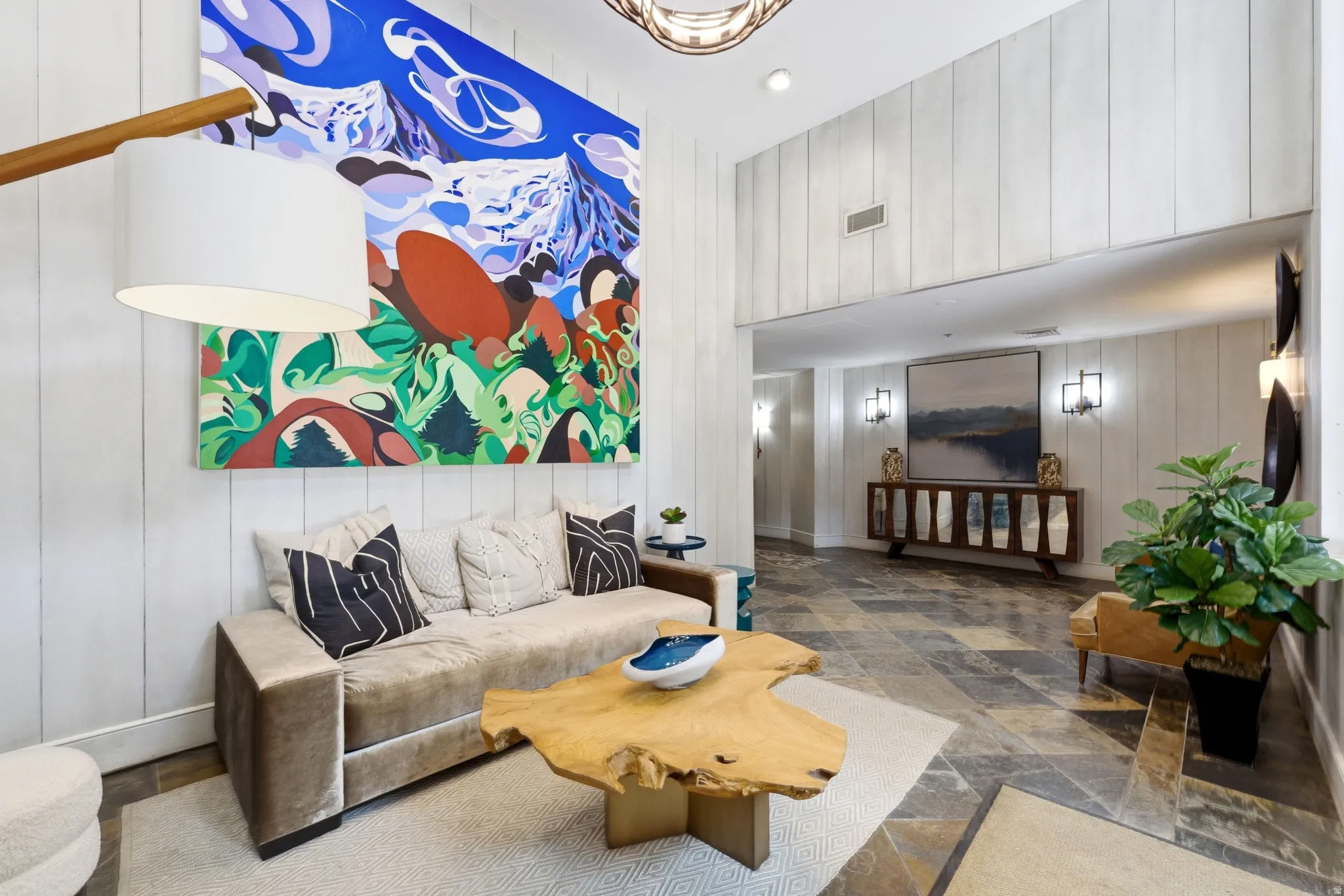 Spacious living area featuring vertical paneling, recessed lighting, a built-in air vent, and multi-toned stone tile flooring