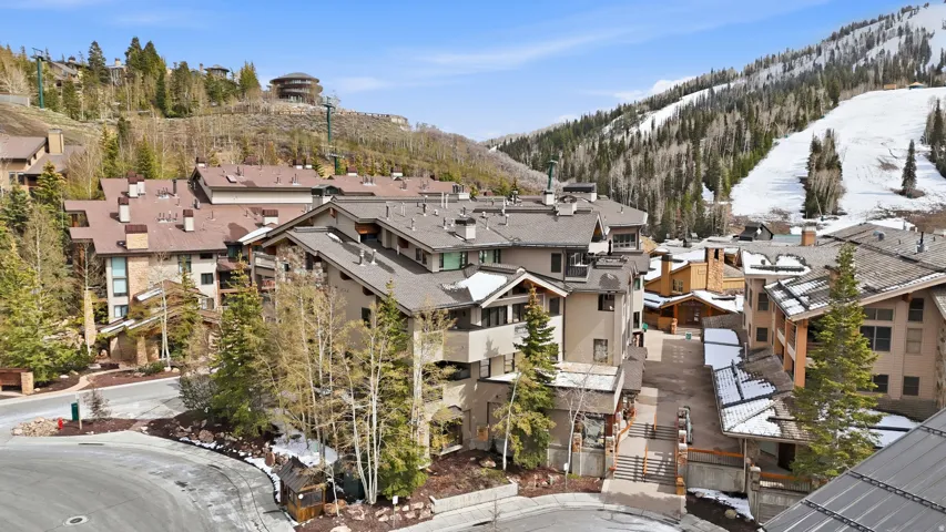 Hillside multi-story buildings featuring stone and stucco exteriors, multiple balconies, and a paved street