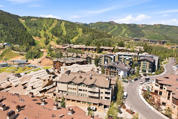 Mountain resort community featuring multiple residential buildings with varied architectural styles, including stone and wood-clad facades