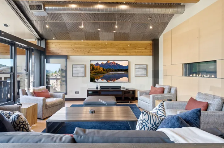 Open living space featuring wood-finish flooring and a distinctive ceiling with exposed ductwork