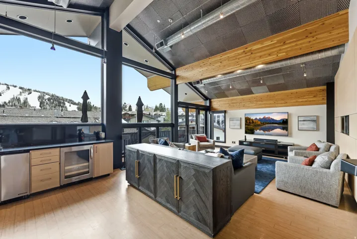 Vaulted ceiling with exposed wood beams and architectural lighting