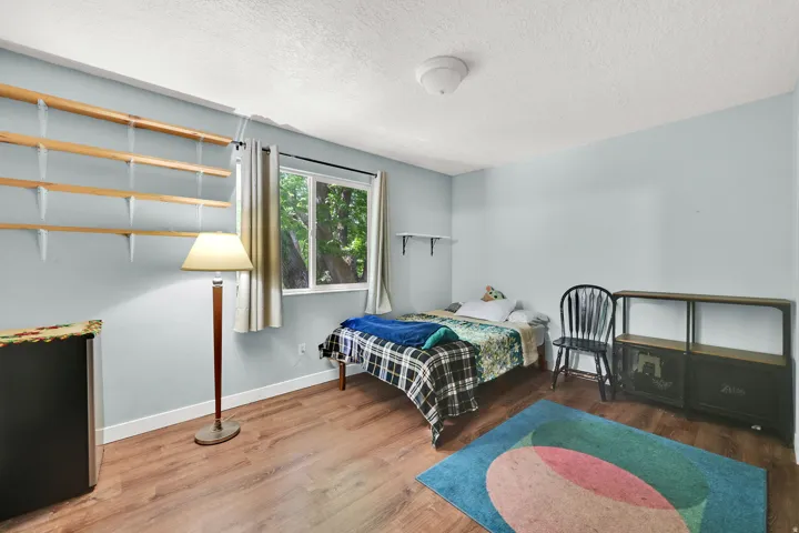 Bedroom with wood finished floors and a textured ceiling