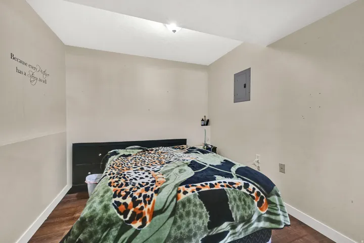 Bedroom featuring dark wood finished floors and electric panel