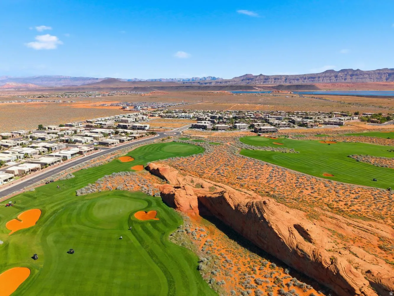 Aerial perspective of suburban area with a golf course and a water and mountain view