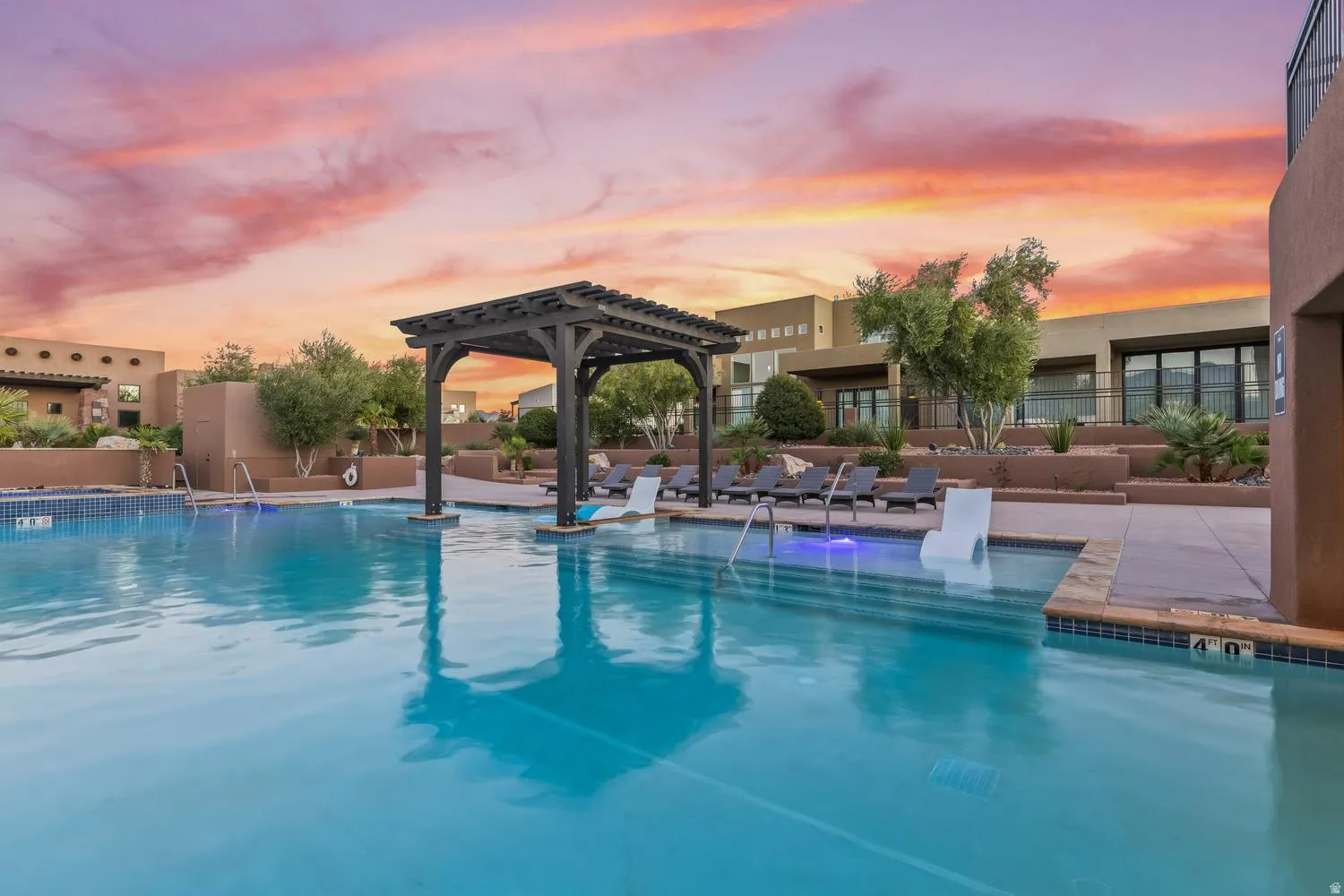 Pool at dusk with a community pool, a pergola, and a patio area