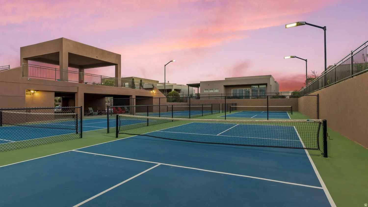 View of tennis court featuring a balcony