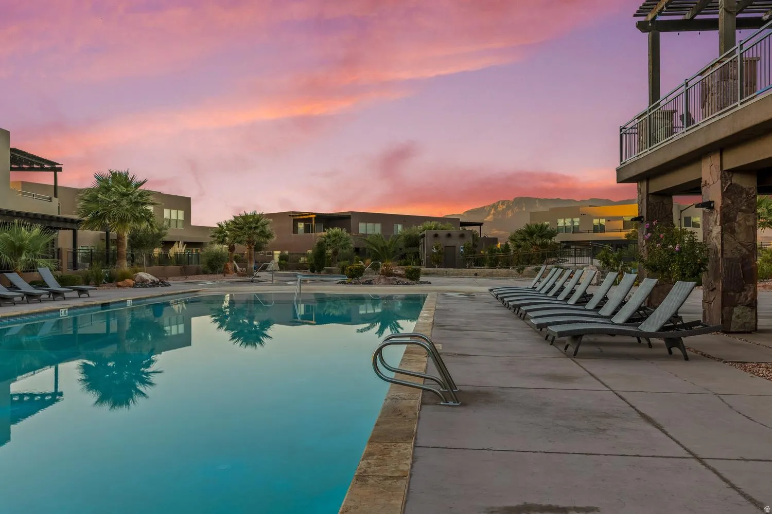 Pool at dusk with a community pool, a patio area, and a residential view