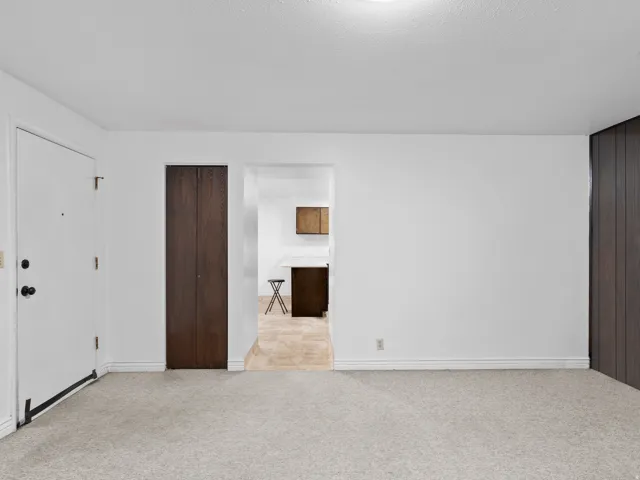 Unfurnished bedroom with light carpet and baseboards