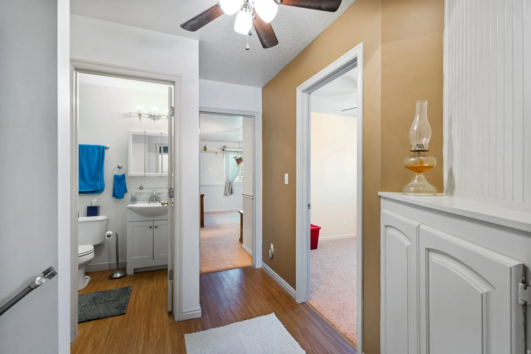 Half bathroom with vanity, dark wood finished floors, and ceiling fan