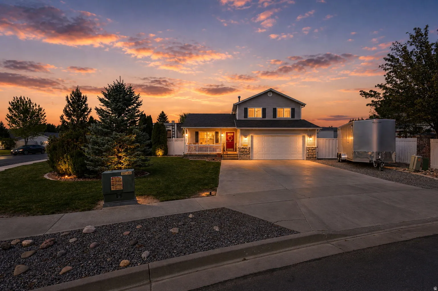 Traditional-style house featuring a porch, driveway, a garage, and stone siding