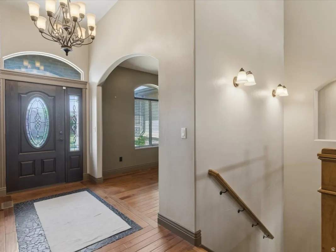 Grand entry foyer featuring a dark wood door with oval leaded glass, a sidelight, and an arched transom window