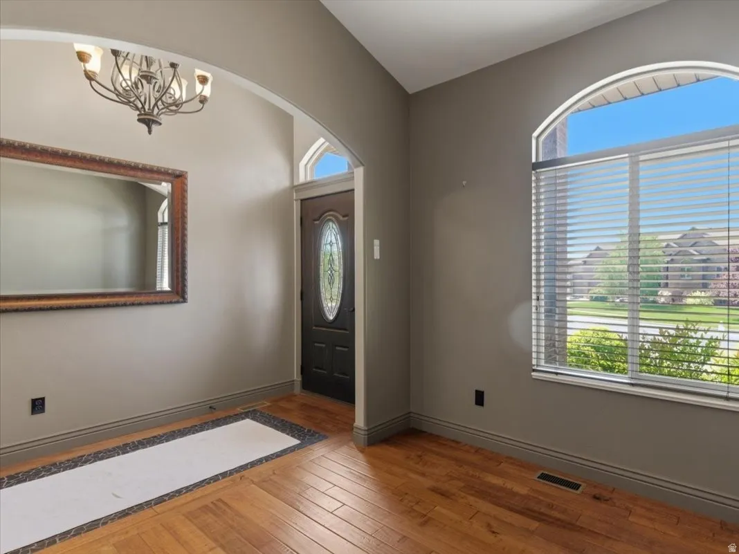 Entryway featuring rich wood-finish flooring with a decorative tile inlay