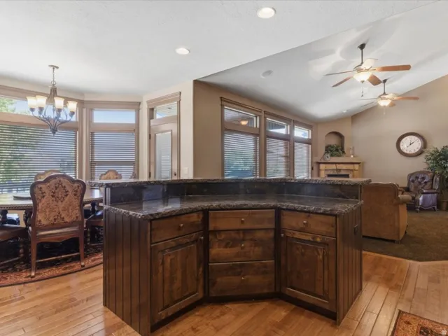 Central kitchen island with dark wood cabinetry and stone-finish countertop