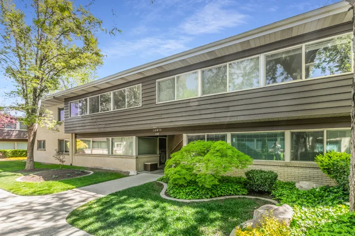 View of front of property featuring brick siding and a front lawn