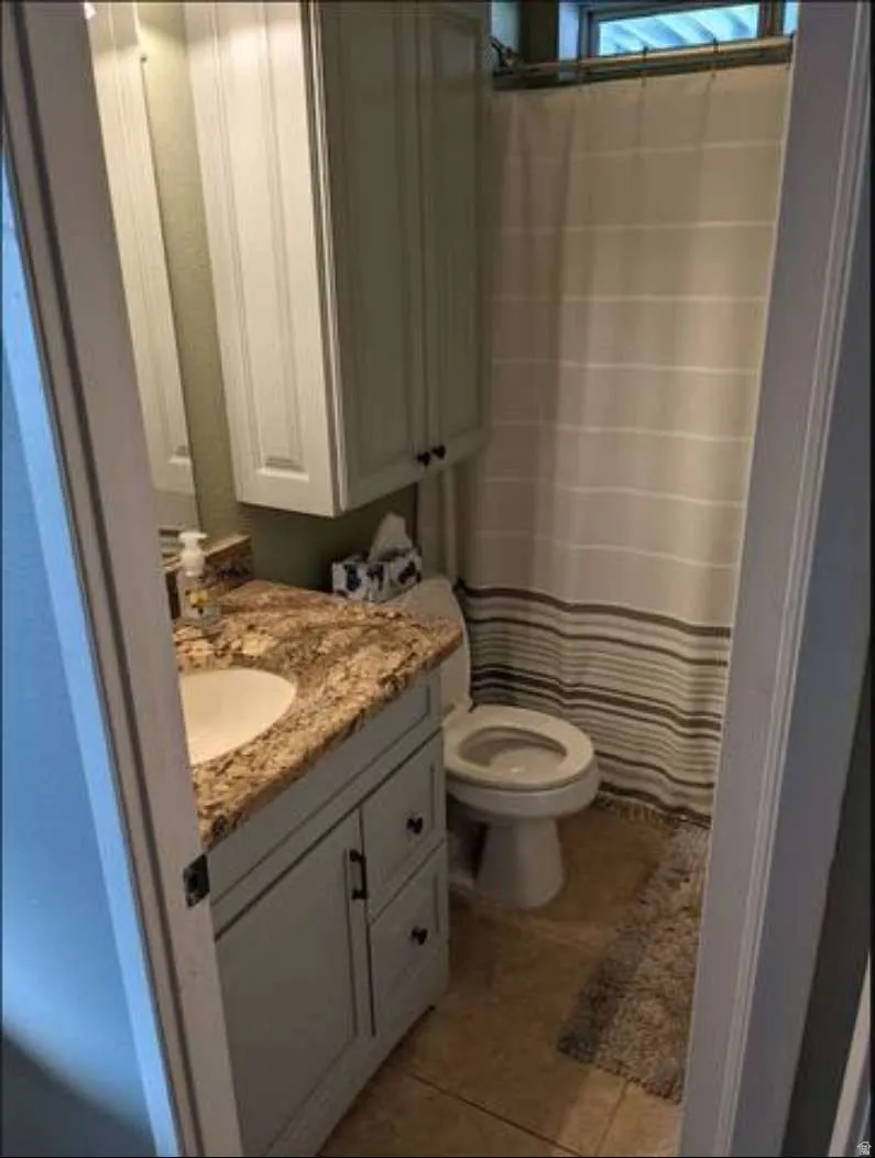 Full bath with vanity, a shower with curtain, and light tile patterned floors