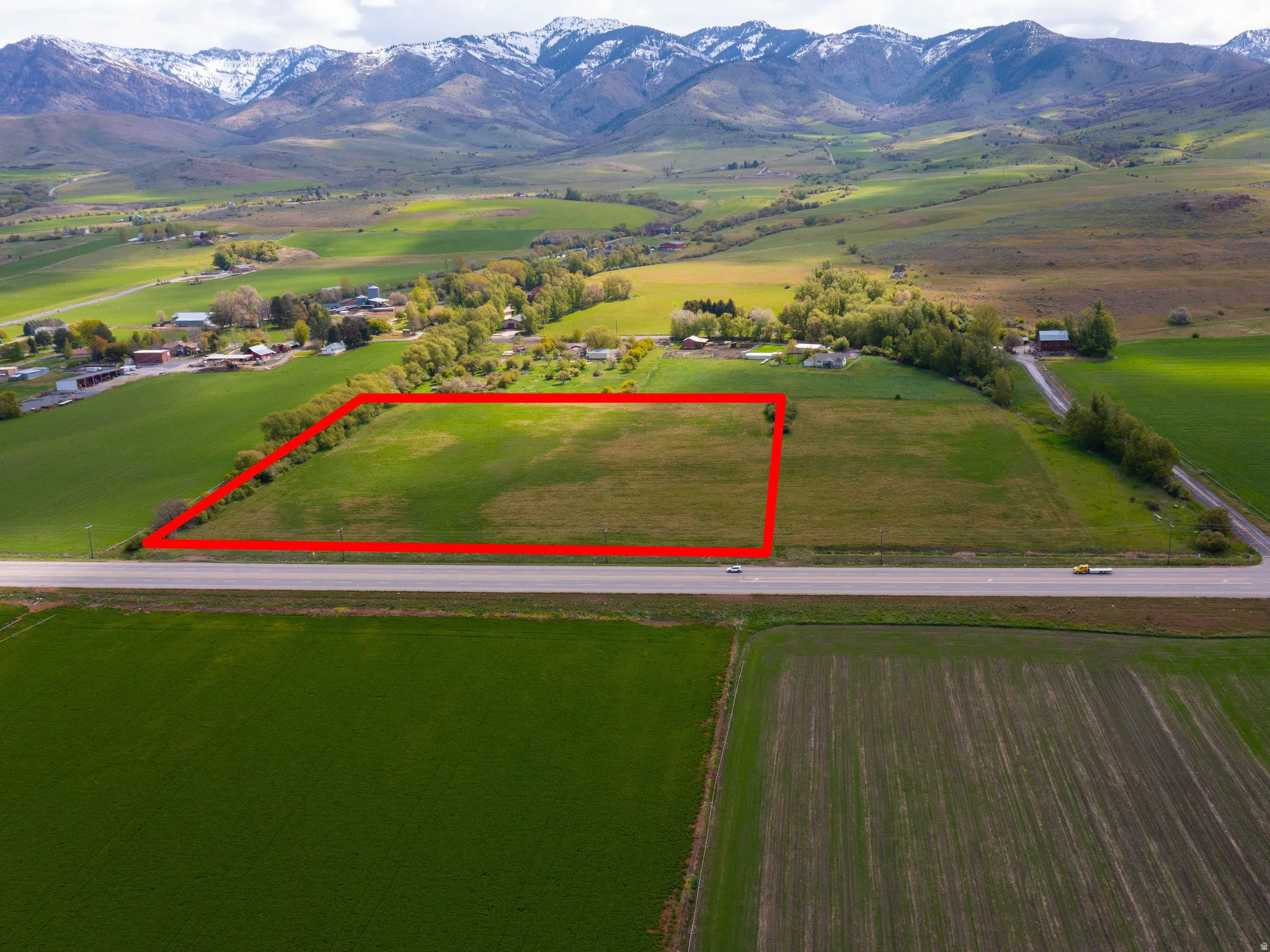 Overview of rural landscape featuring property boundaries highlighted and a mountainous background