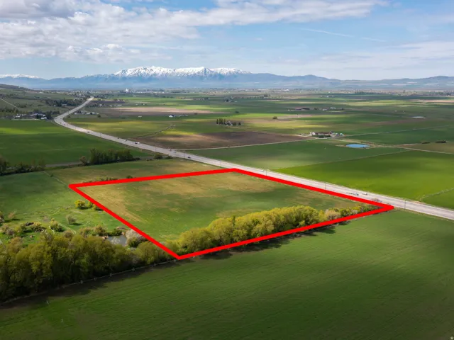 Aerial view of sparsely populated area featuring property parcel outlined and a mountainous background