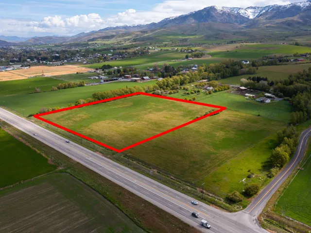 Aerial overview of property's location featuring rural landscape, a mountainous background, and property boundaries highlighted