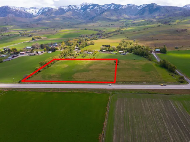 Overview of rural landscape featuring property boundaries highlighted and a mountainous background