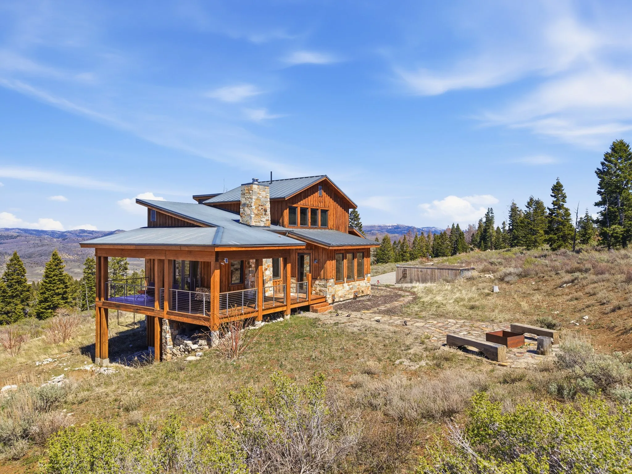 Back of property with a mountain view, board and batten siding, a porch, a metal roof, and a chimney