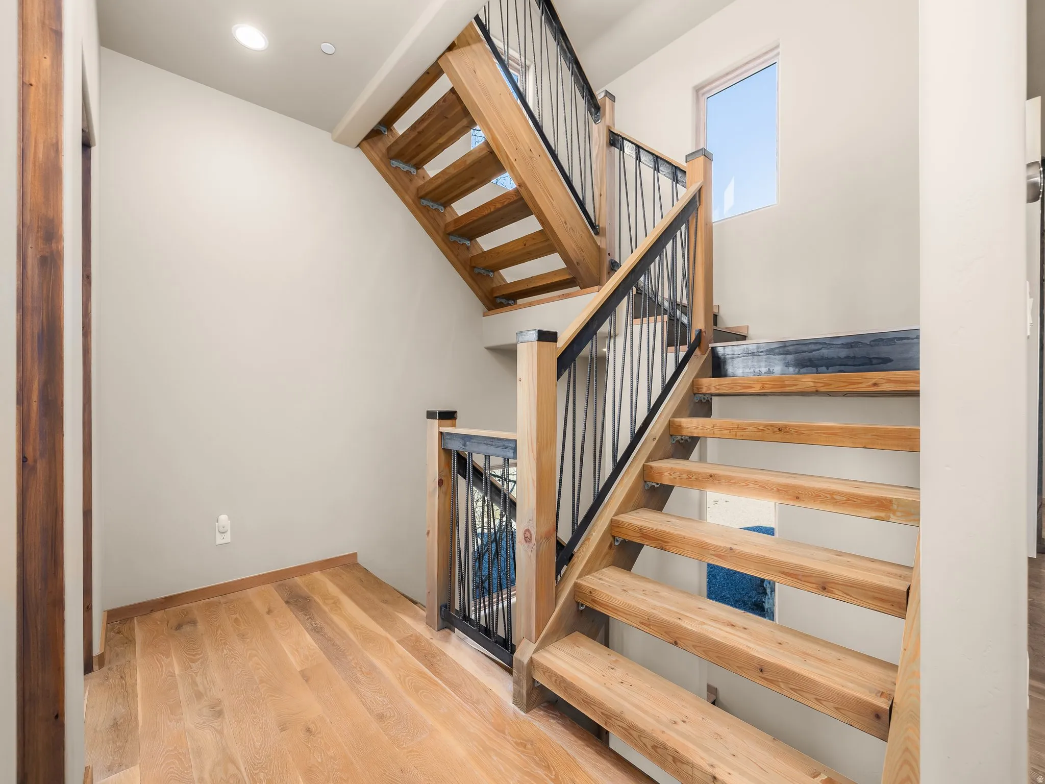 Stairs featuring wood finished floors and baseboards