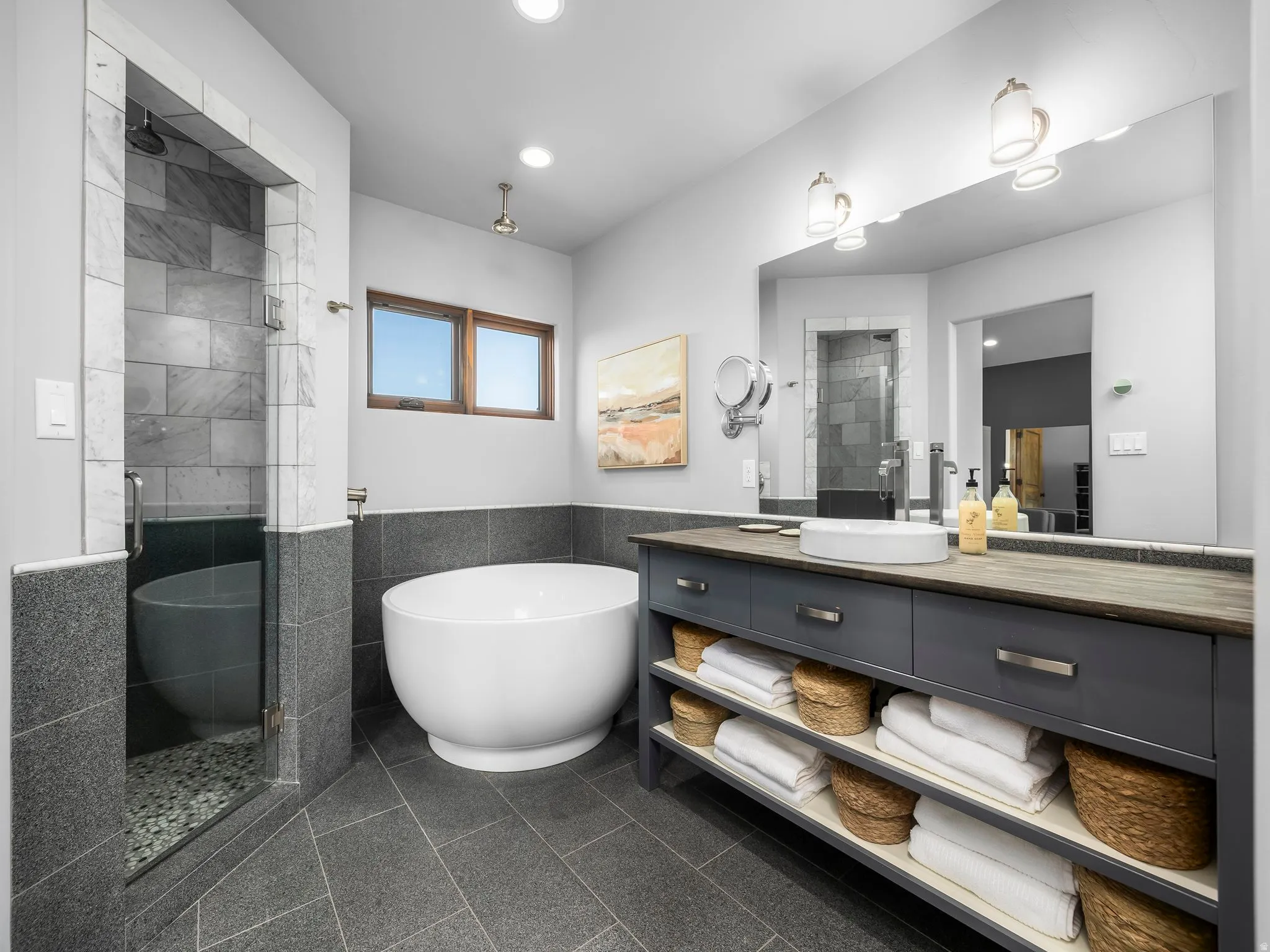 Full bath with vanity, a shower stall, tile walls, a freestanding tub, and granite floors