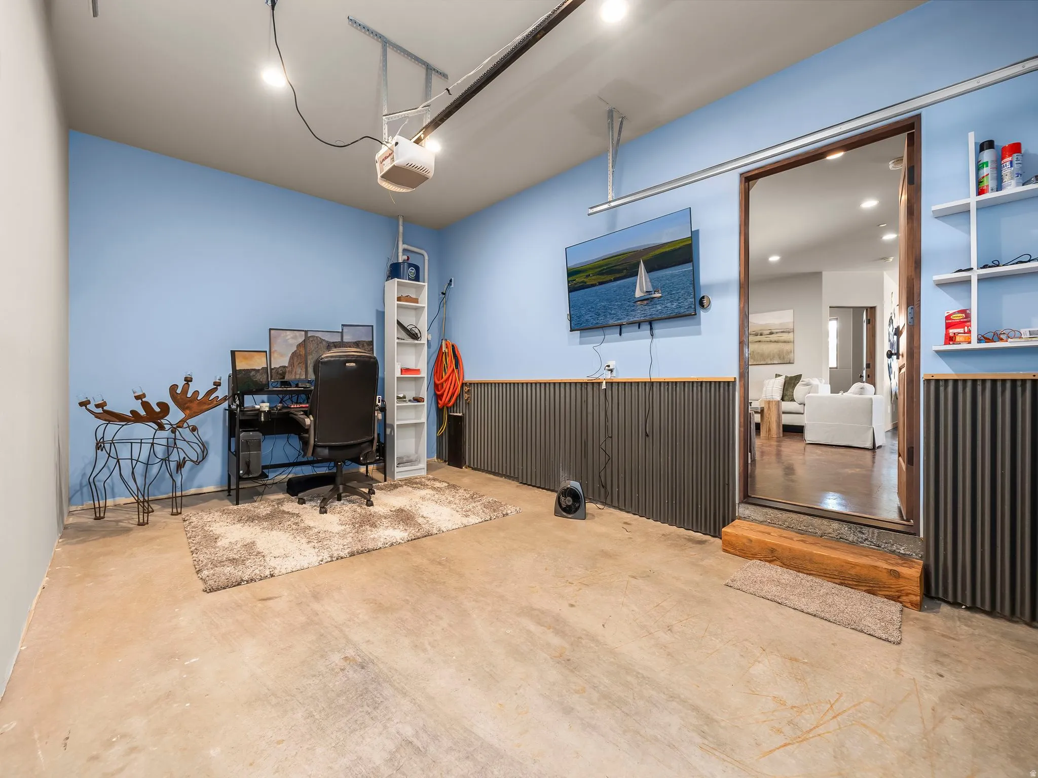 Home office featuring a garage, concrete floors, recessed lighting, wainscoting, and wooden walls
