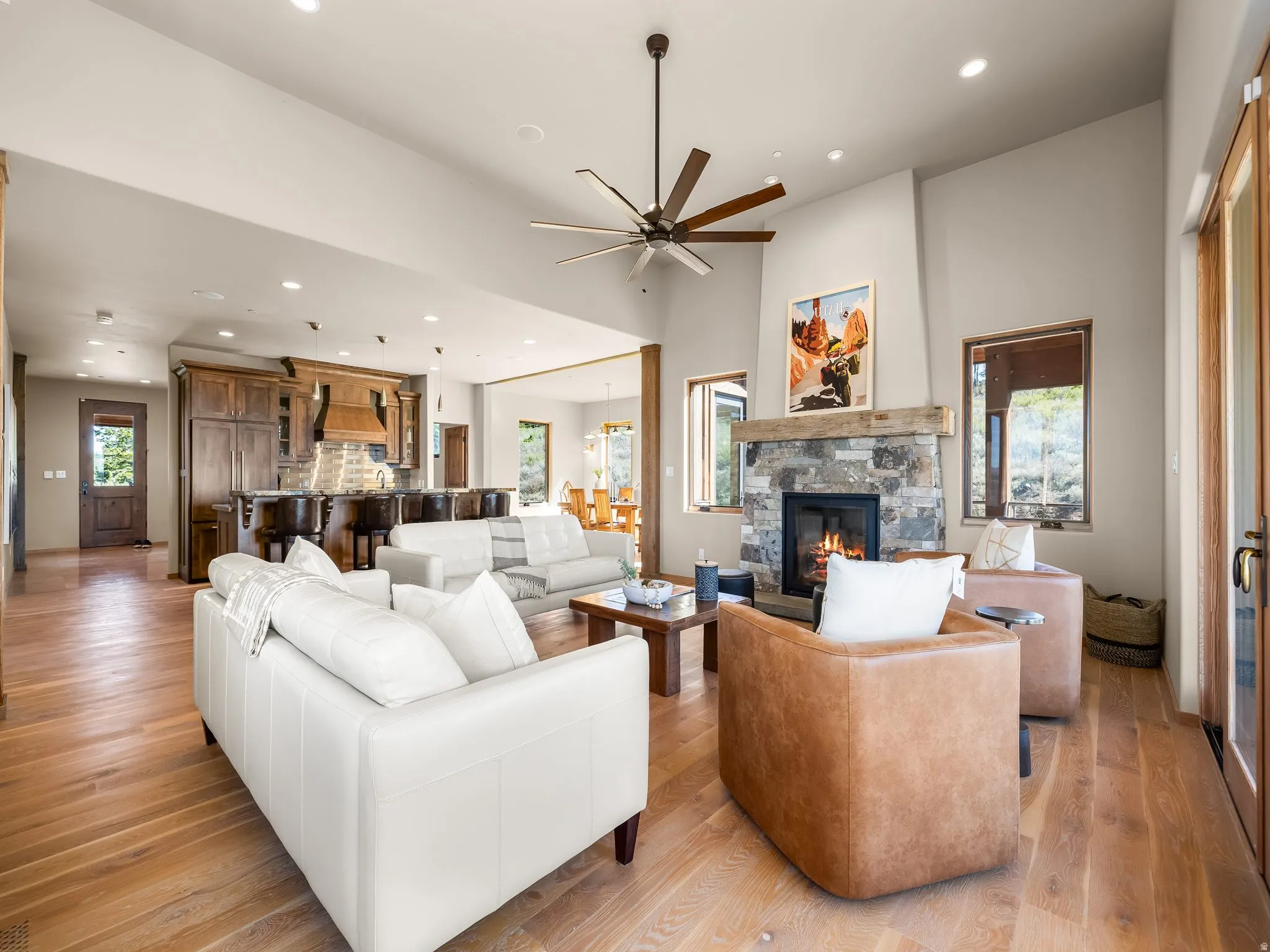 Living area featuring a ceiling fan, a fireplace, light wood-style flooring, and recessed lighting