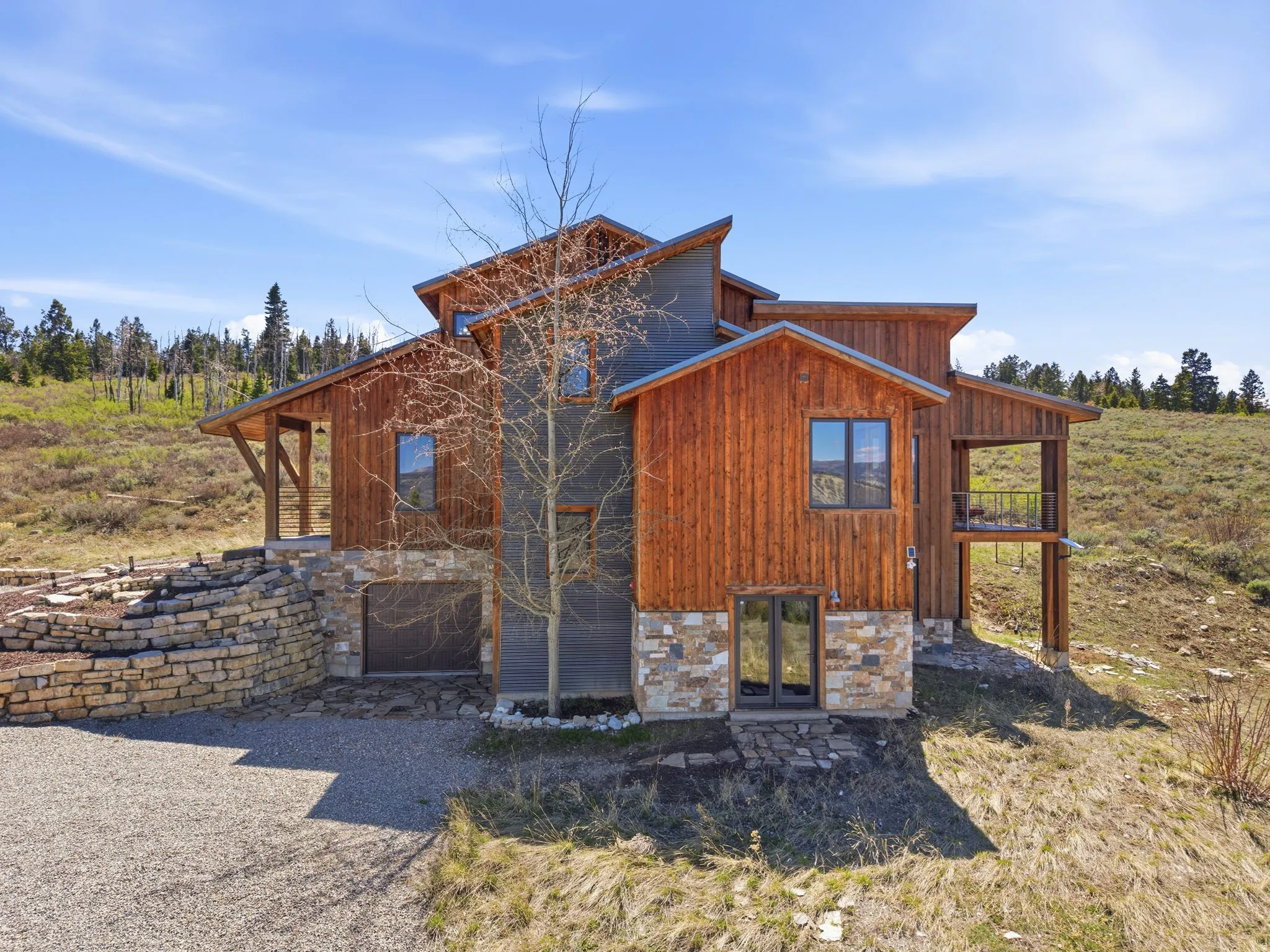 View of front facade with stone siding and french doors