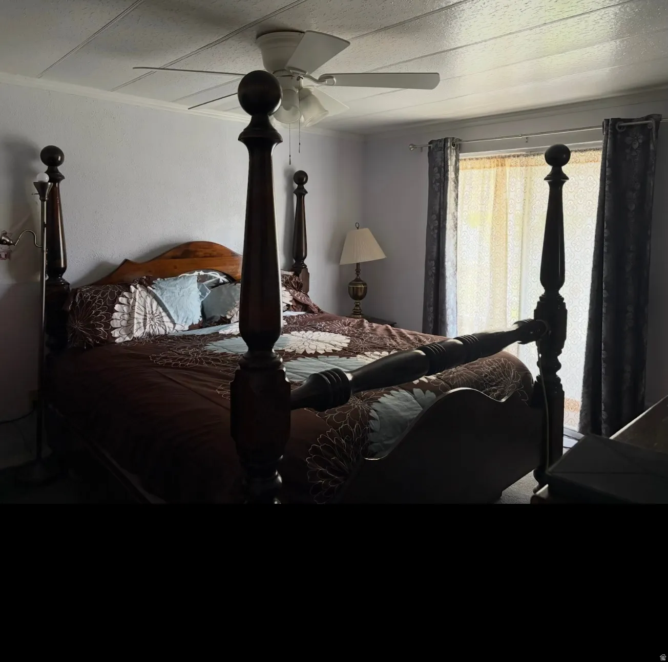 Bedroom with a ceiling fan and a textured ceiling