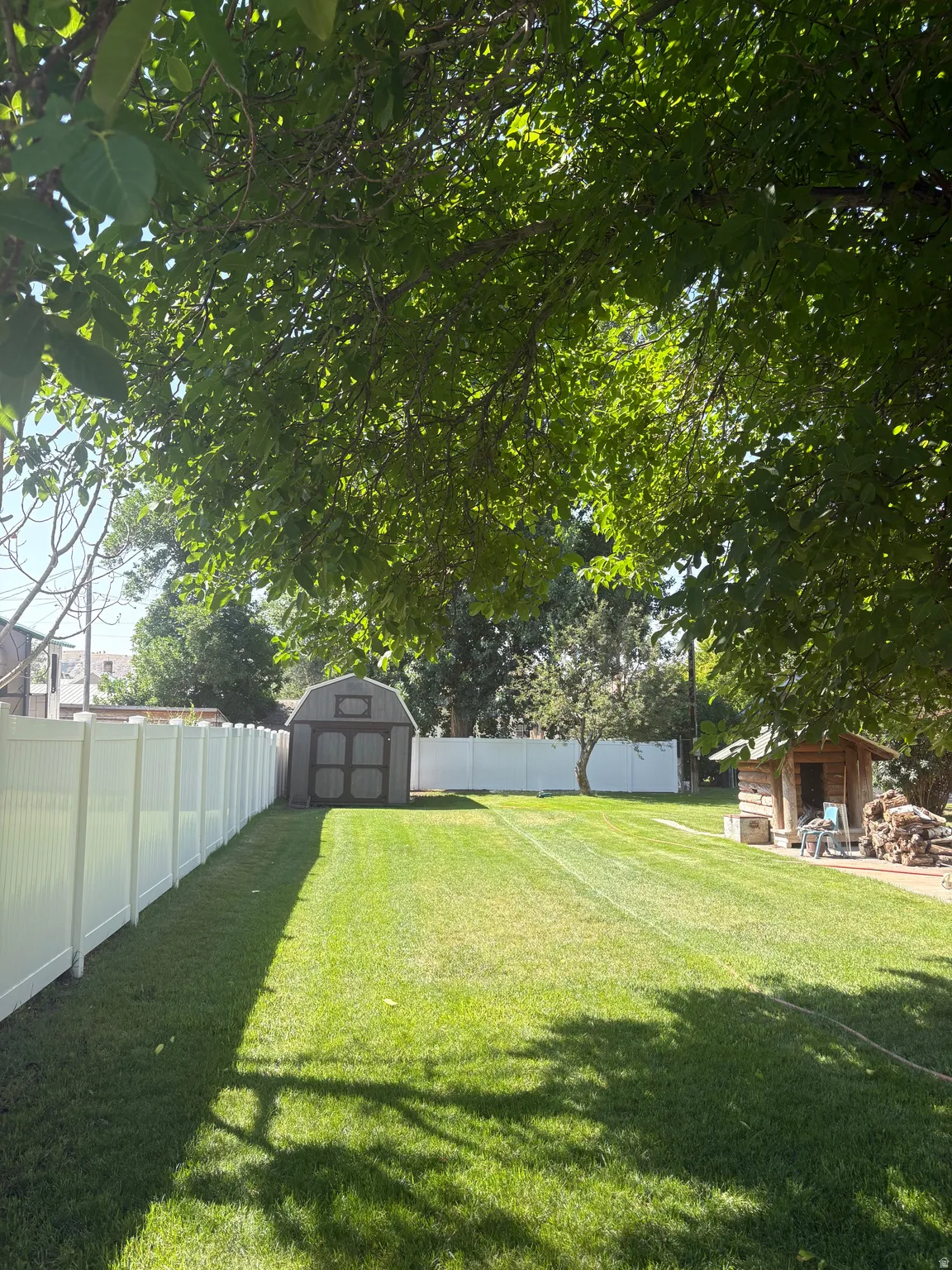 Fenced backyard with a storage shed
