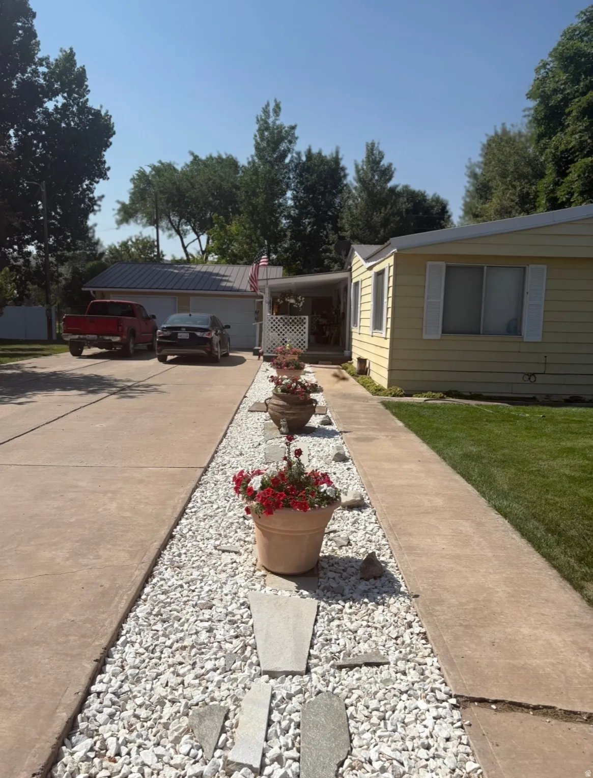 View of green lawn featuring concrete driveway