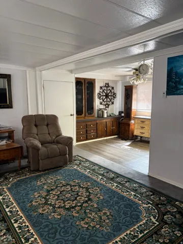 Living area featuring crown molding and ceiling fan