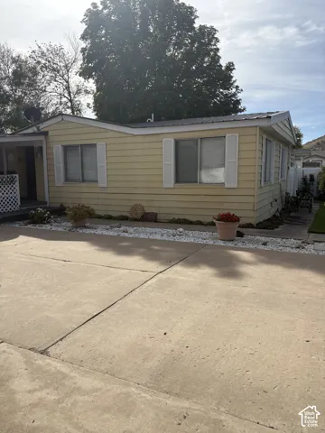 Yellow horizontal siding exterior with white window shutters