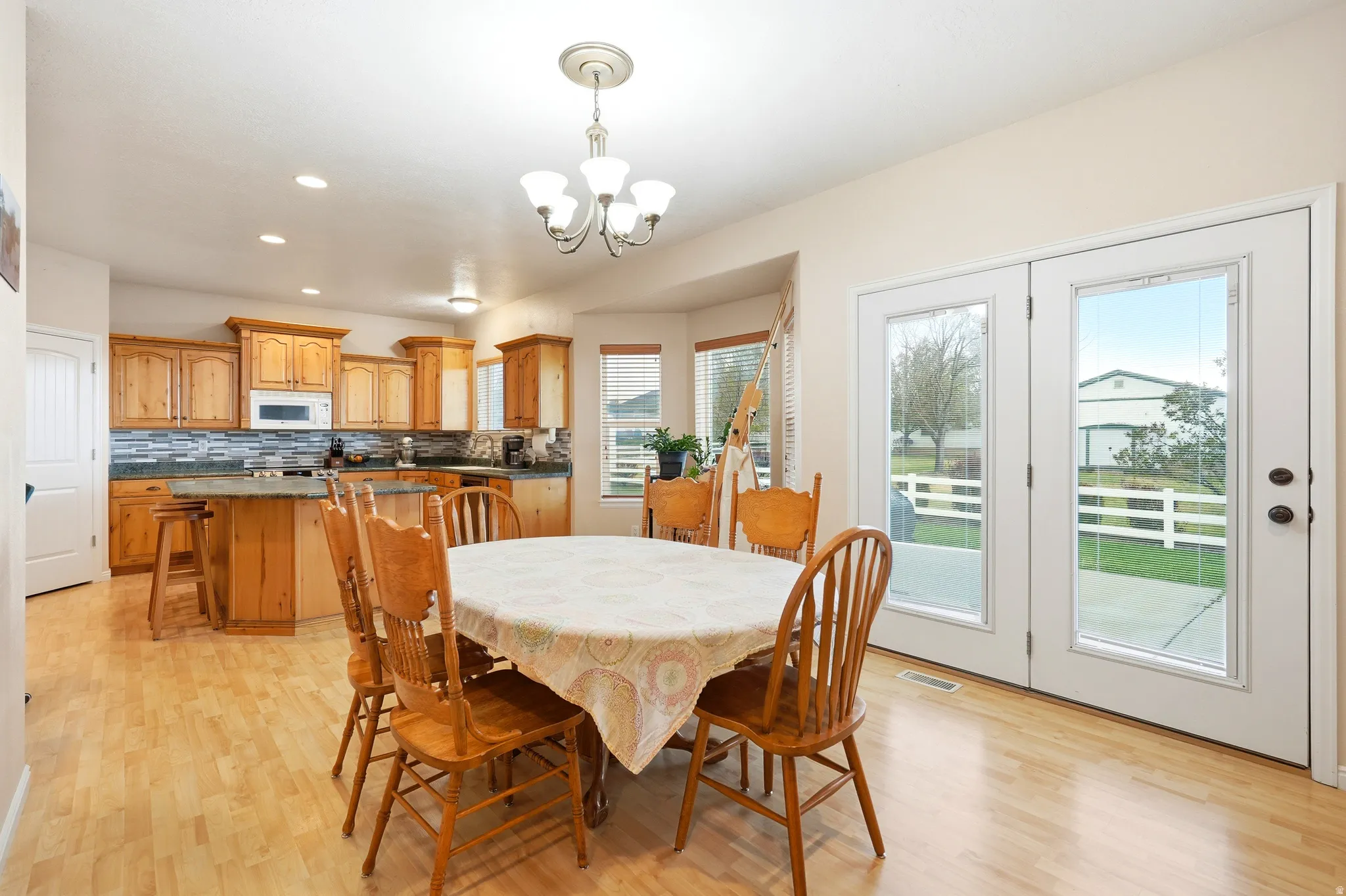 Dining space featuring light wood-type flooring and a chandelier
