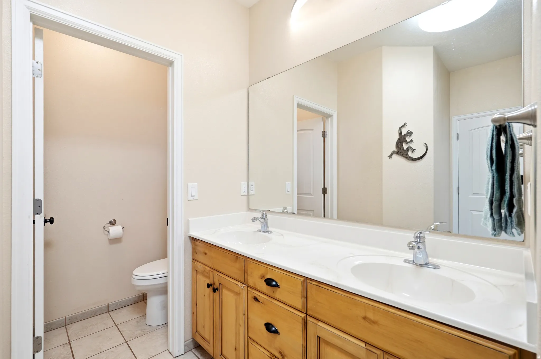 Full bath featuring light tile patterned floors and double vanity
