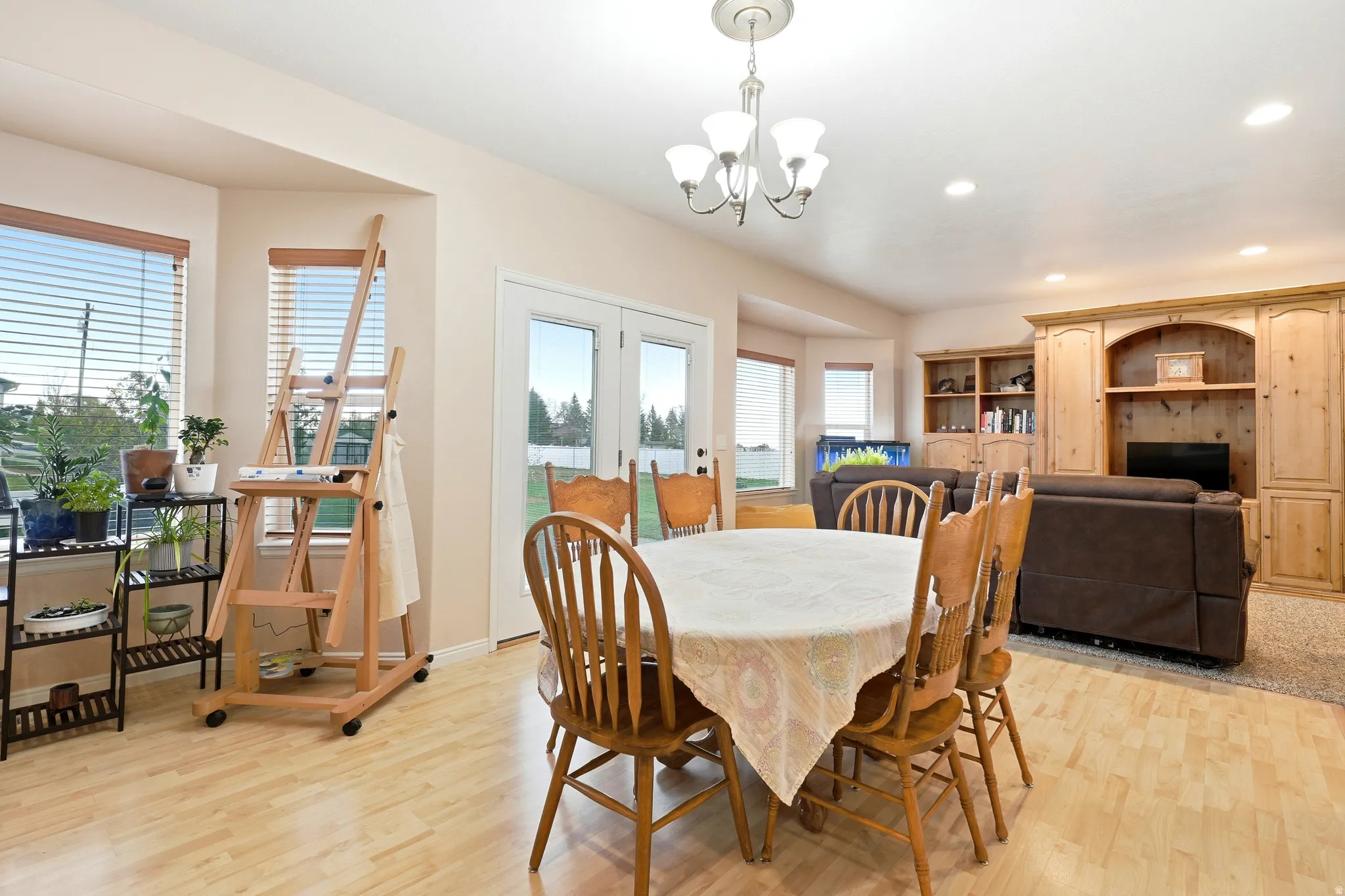 Dining room featuring light wood-type flooring, french doors, and a chandelier