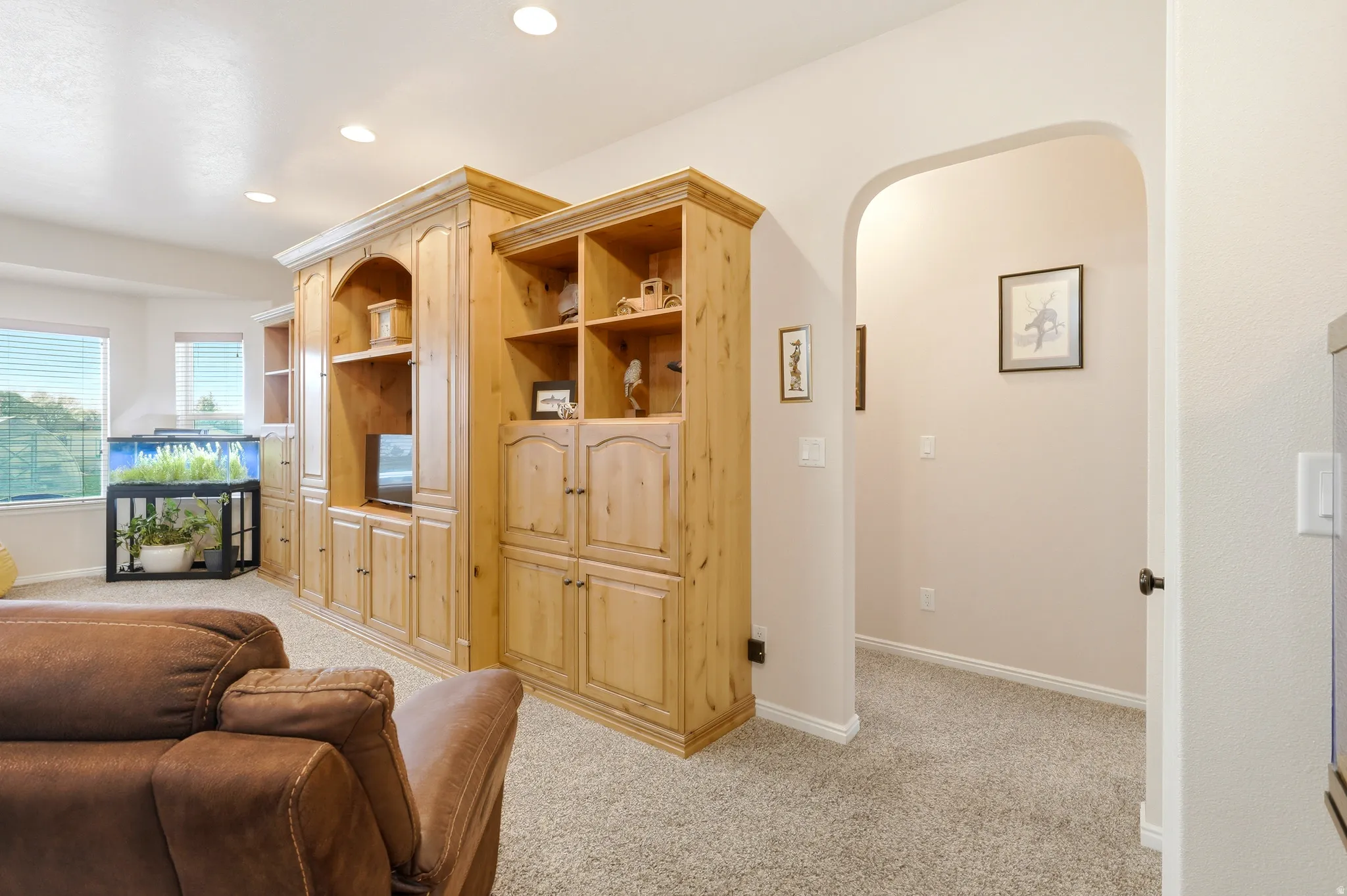 Living room with arched walkways, light colored carpet, and recessed lighting