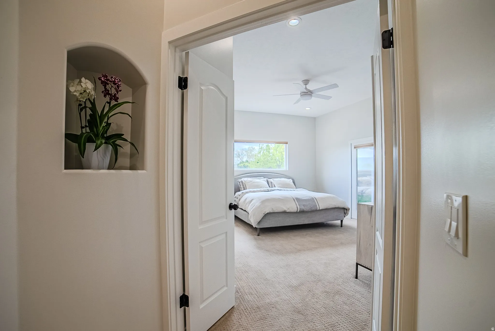 Bedroom with light carpet, ceiling fan, and recessed lighting
