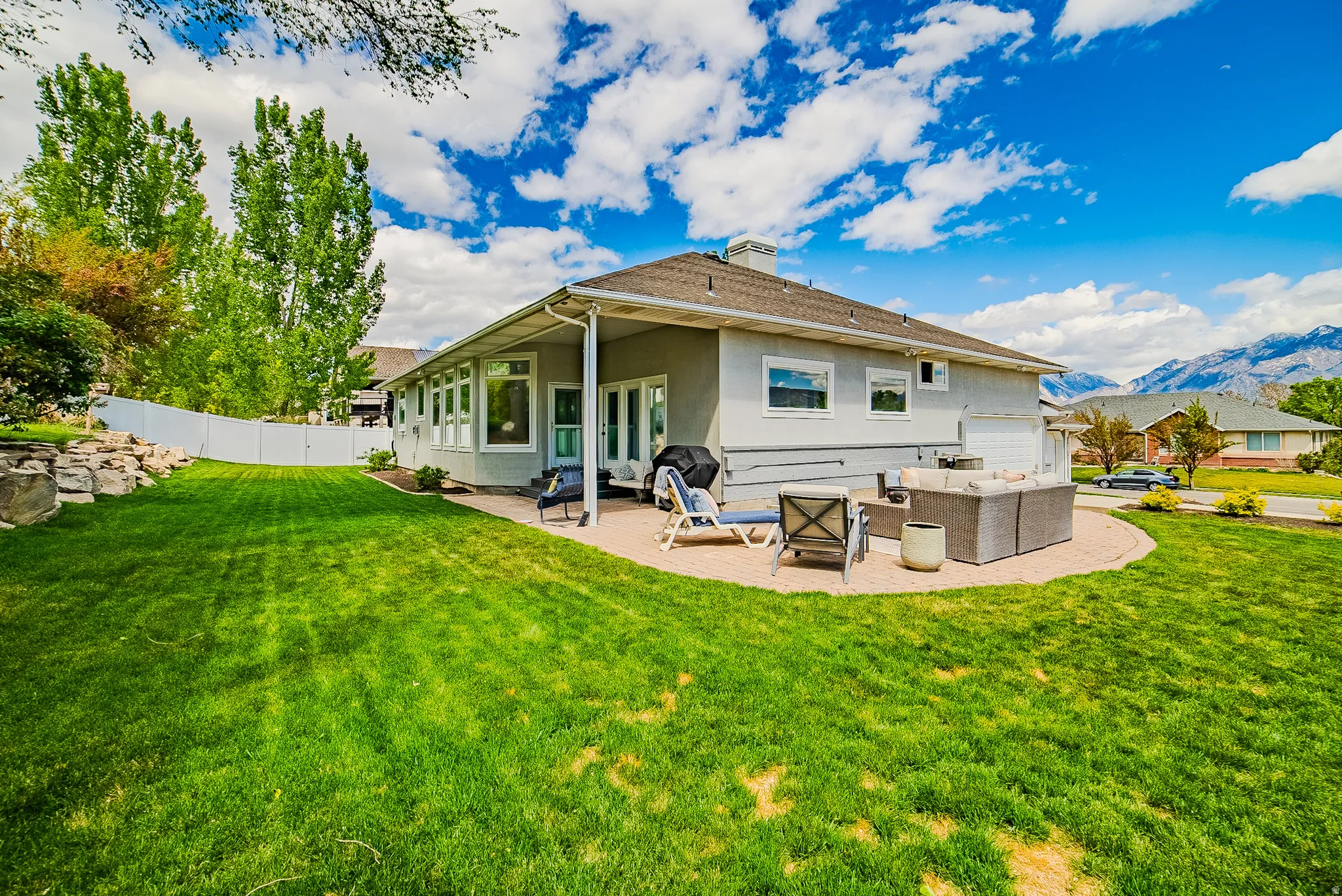 Back of property featuring an outdoor lounge area, a patio area, a mountain view, and a chimney