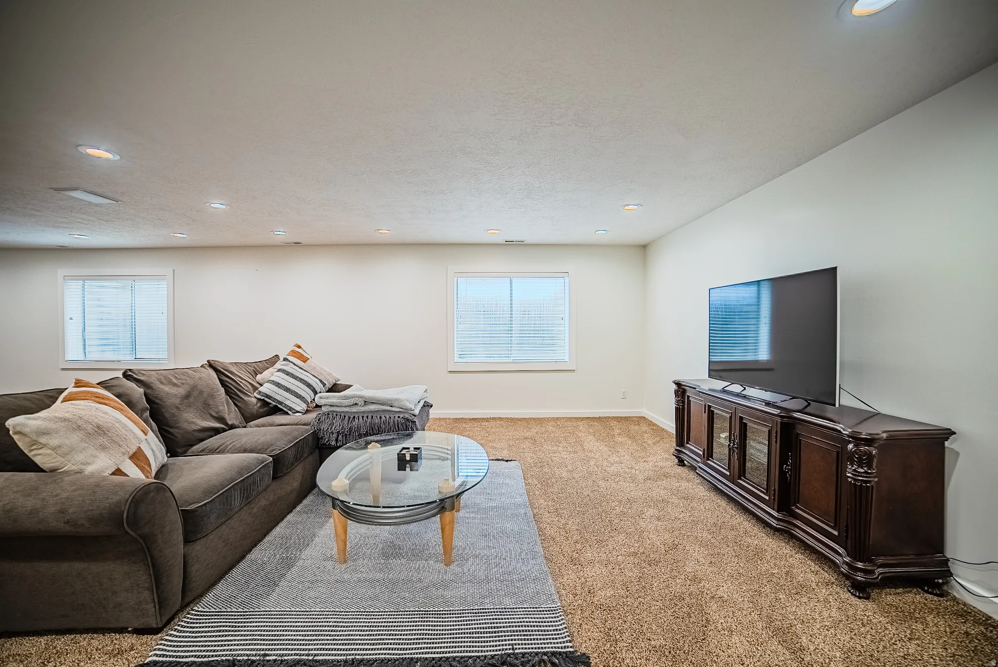 Living room featuring light colored carpet, recessed lighting, healthy amount of natural light, and a textured ceiling