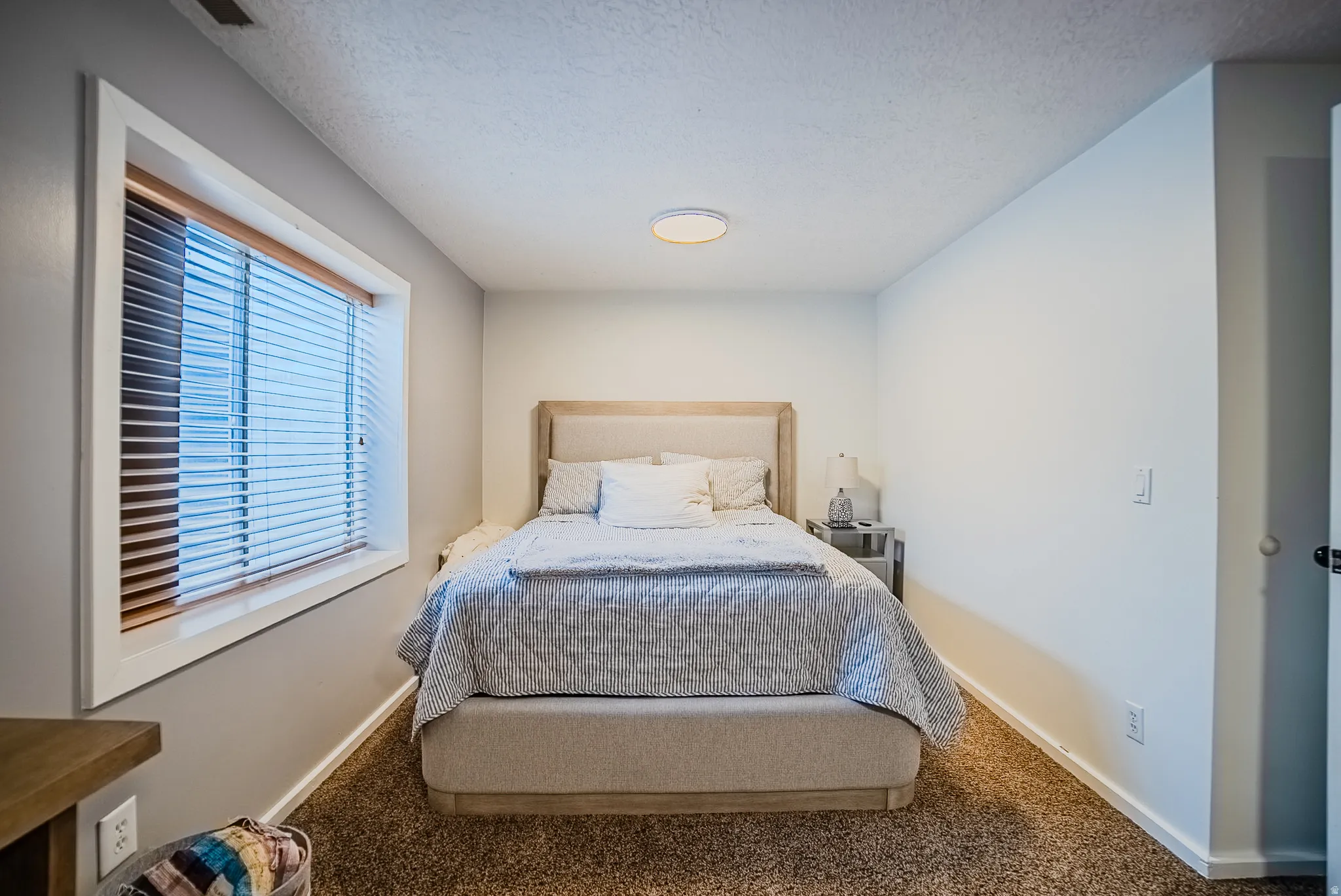 Bedroom with carpet and a textured ceiling