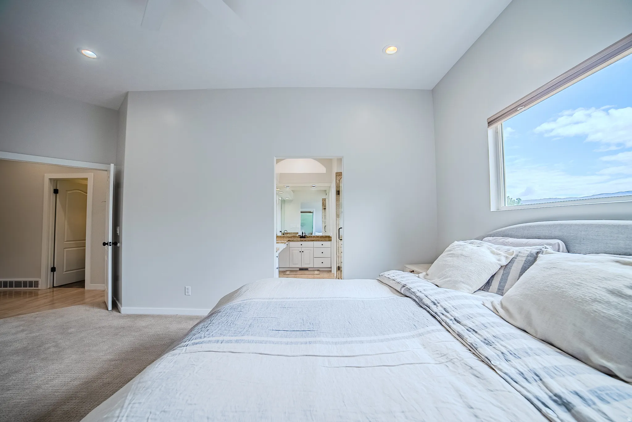 Bedroom with light carpet, ceiling fan, recessed lighting, and ensuite bathroom